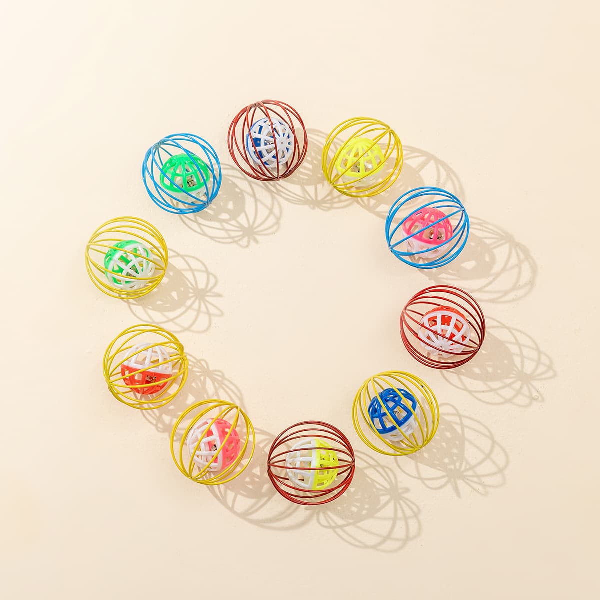 Assorted caged bell cat toys arranged on a light surface
